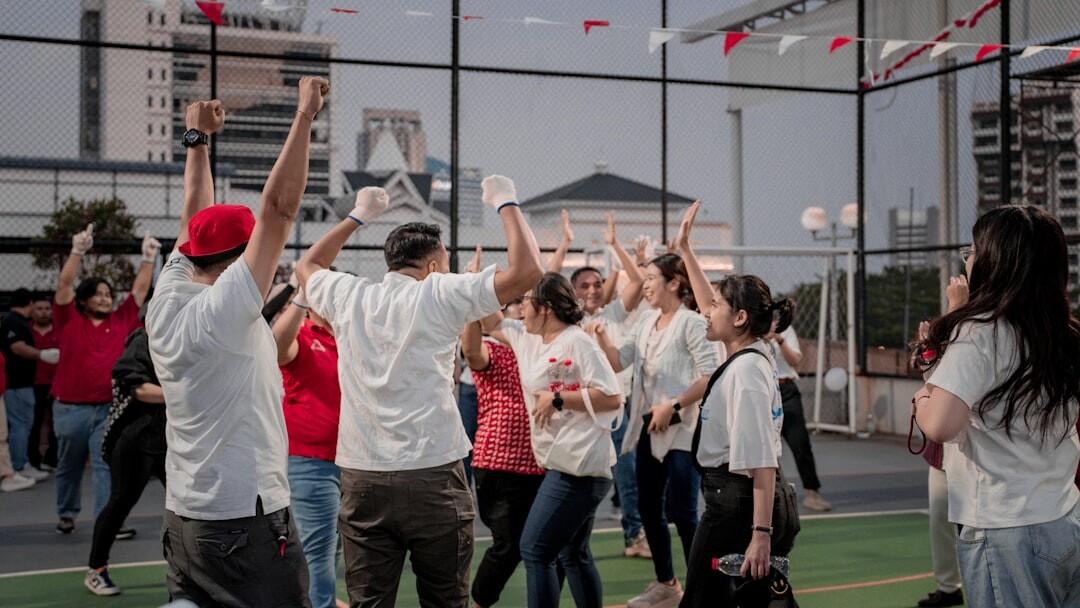 Diverse group of colleagues cheering outdoors during a team building activity