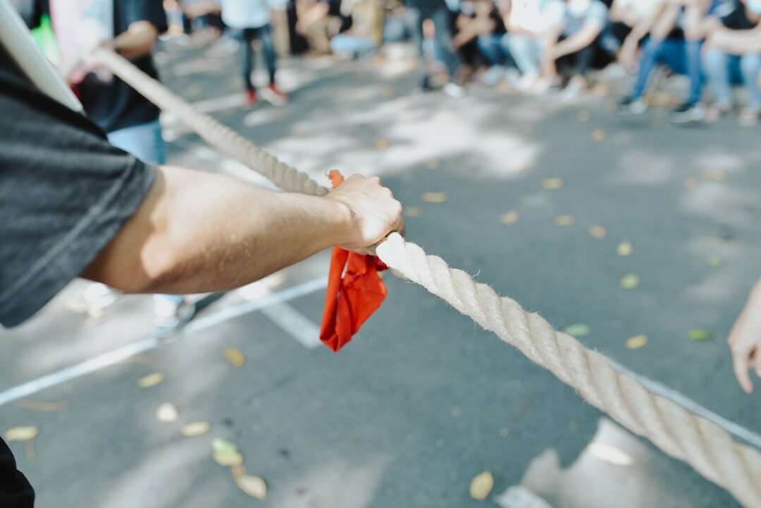 Colleagues playing tug of war during an outdoor corporate olympics event